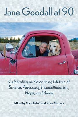 Jane Goodall and her dog peek from a truck window