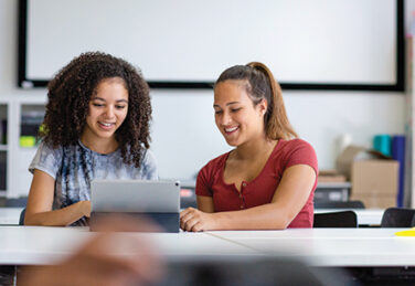 students interact with tablet in classroom