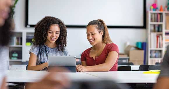 students interact with tablet in classroom