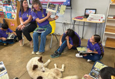 teacher reads book to circle of children in classroom