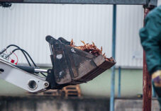 Masses of dead hens lie piled inside the bucket of a loader outside the barns of an egg farm. The hens have been killed and workers wearing protective suits are in the process of removing them from the farm.