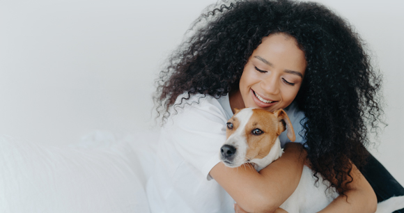 woman embraces dog in the home