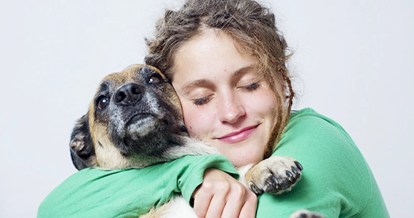 woman embracing her dog lovingly