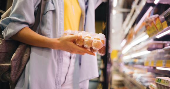 customer holding eggs in a supermarket aisle