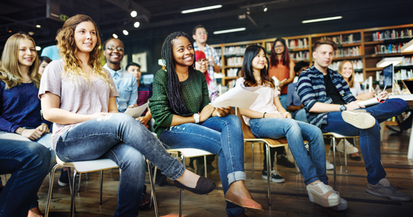 students sit listening intently in a library class